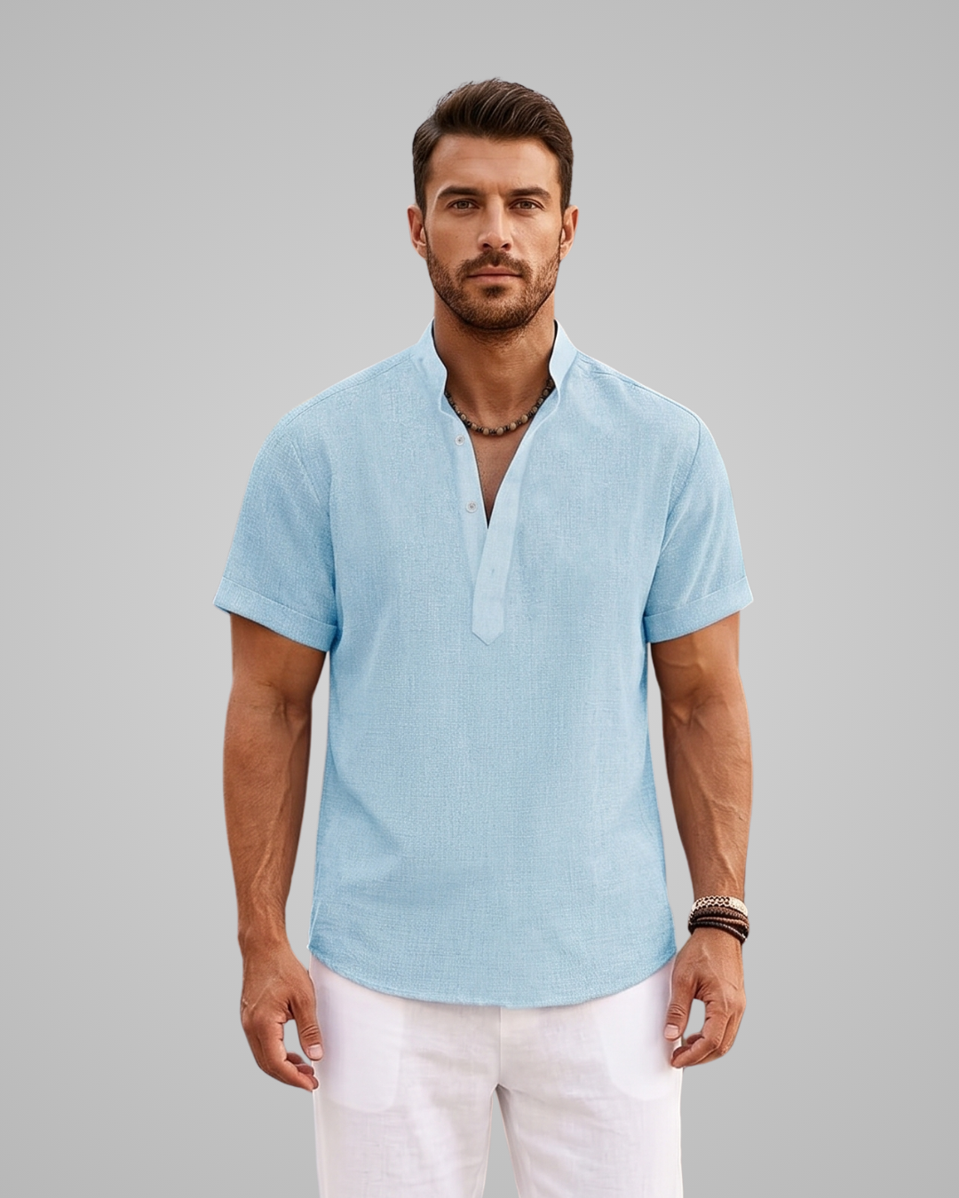 Man wearing a light blue short-sleeve shirt and white pants against a gray background