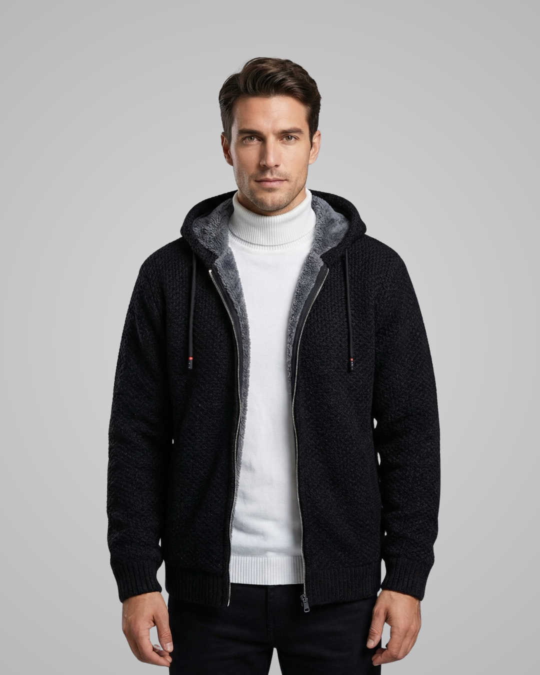 Man wearing a black hooded jacket with gray lining on a gray background
