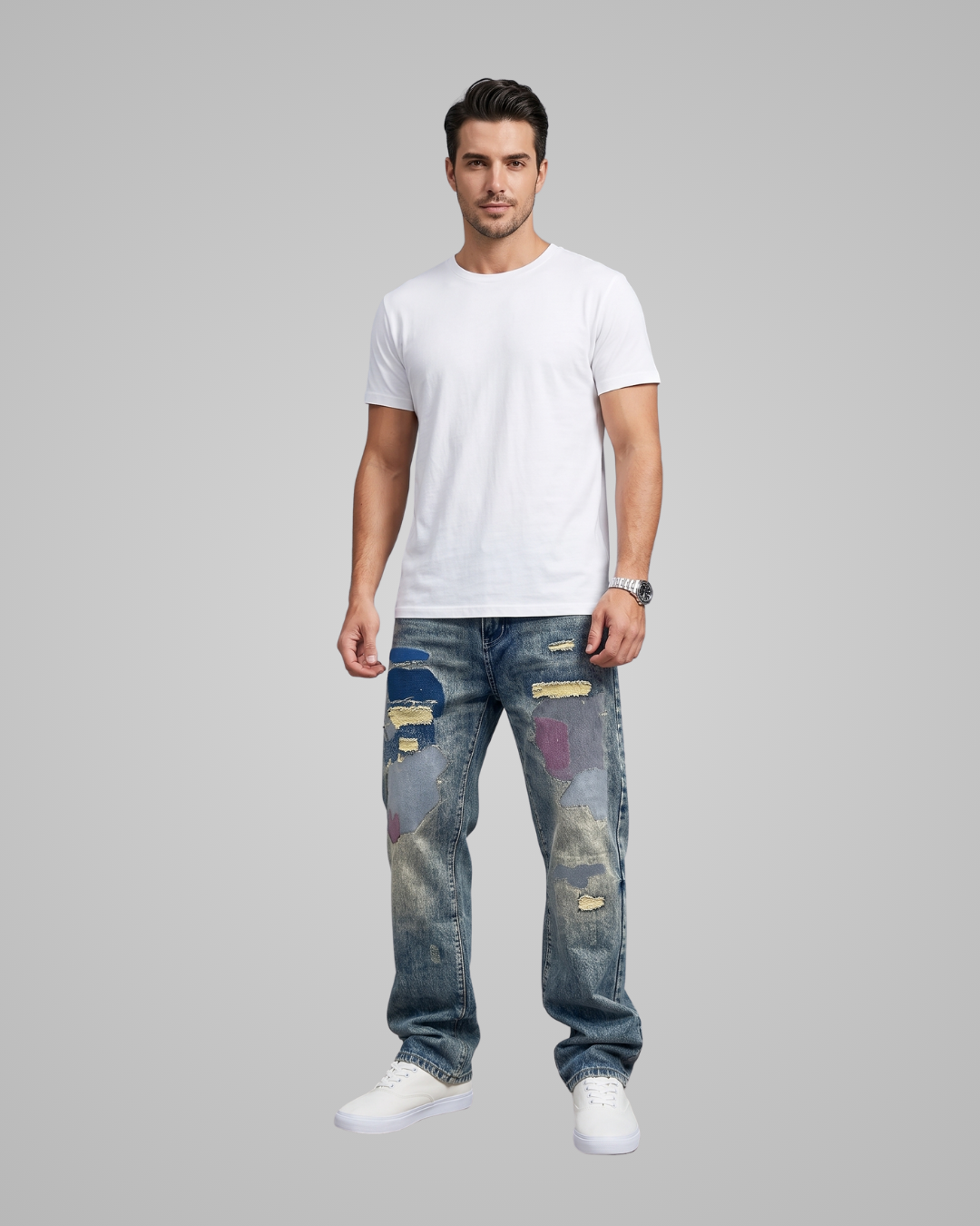 Man wearing a white t-shirt and distressed blue jeans on a gray background