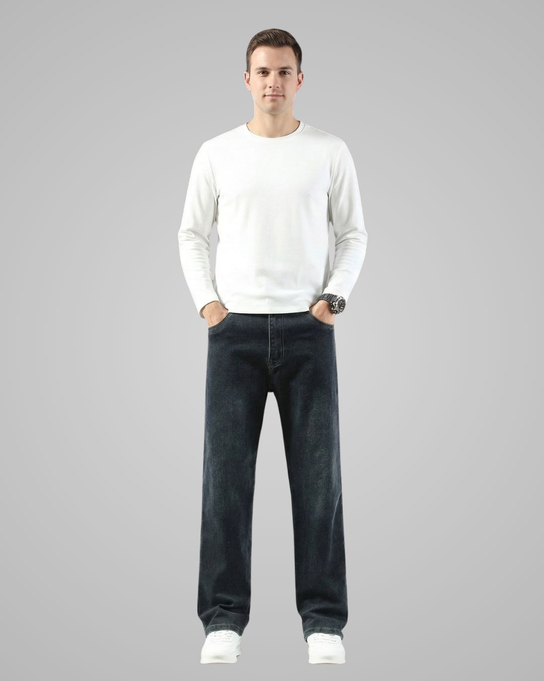 Person wearing a white sweater and dark jeans on a gray background