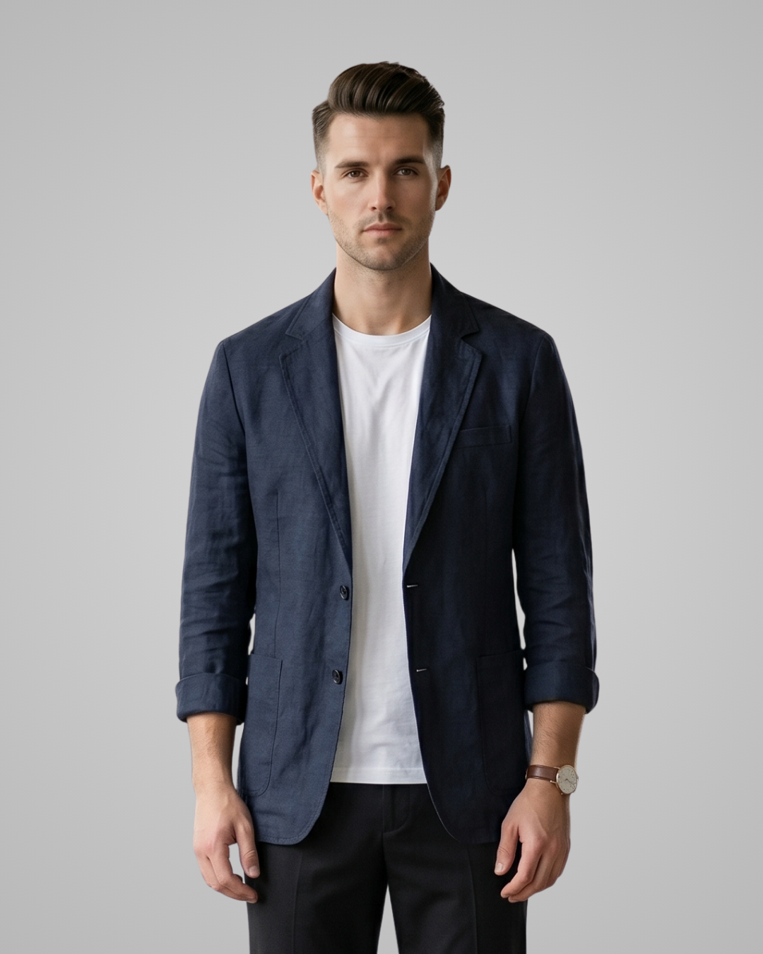 Man wearing a navy blazer over a white shirt on a gray background