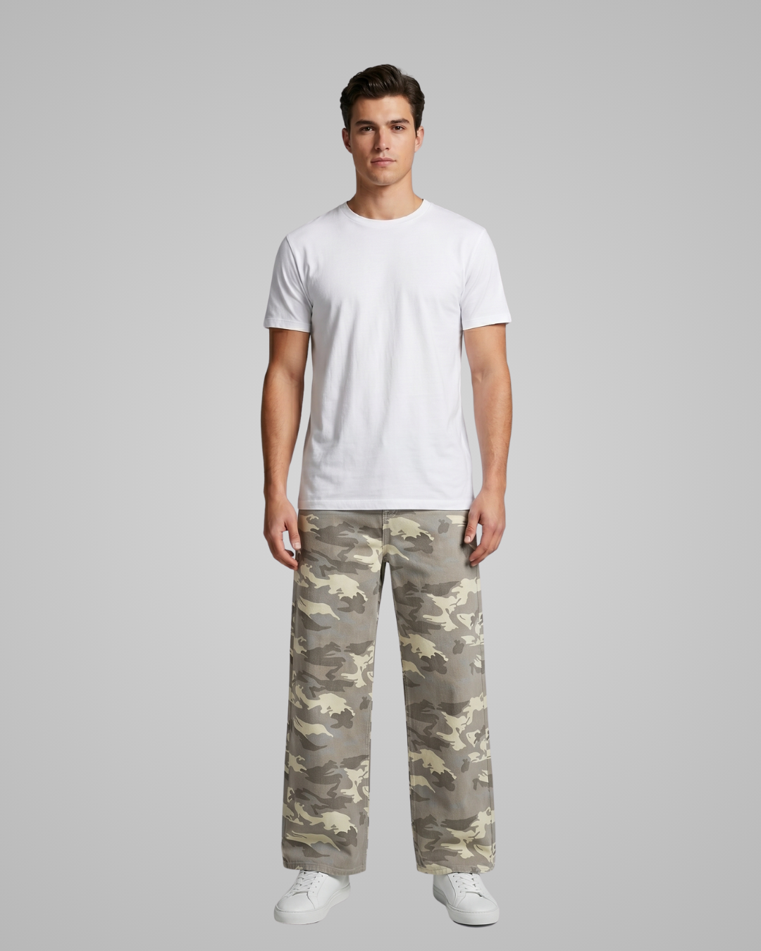 Person wearing a white t-shirt and camouflage pants on a gray background