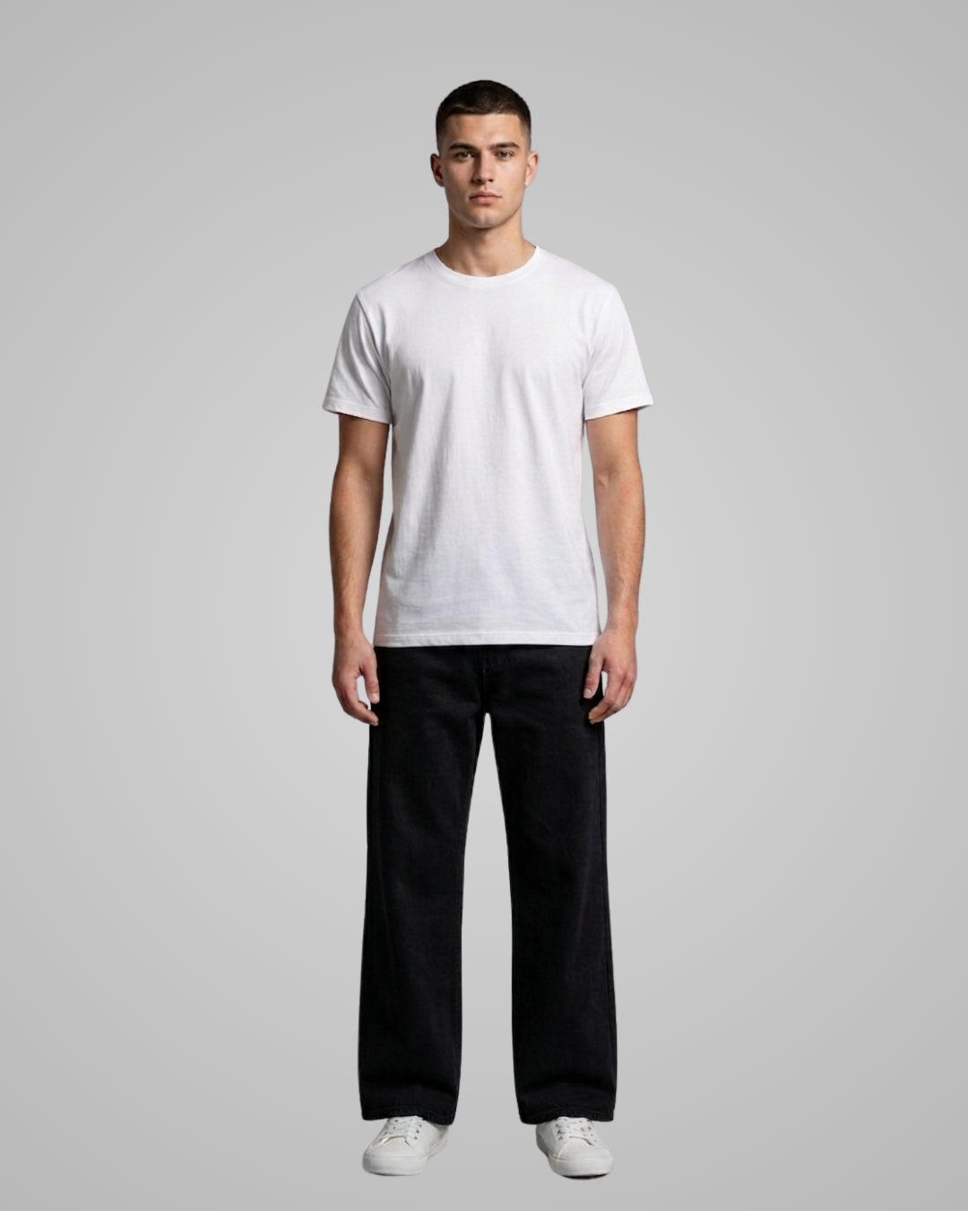 Man wearing a plain white t-shirt and black pants on a gray background