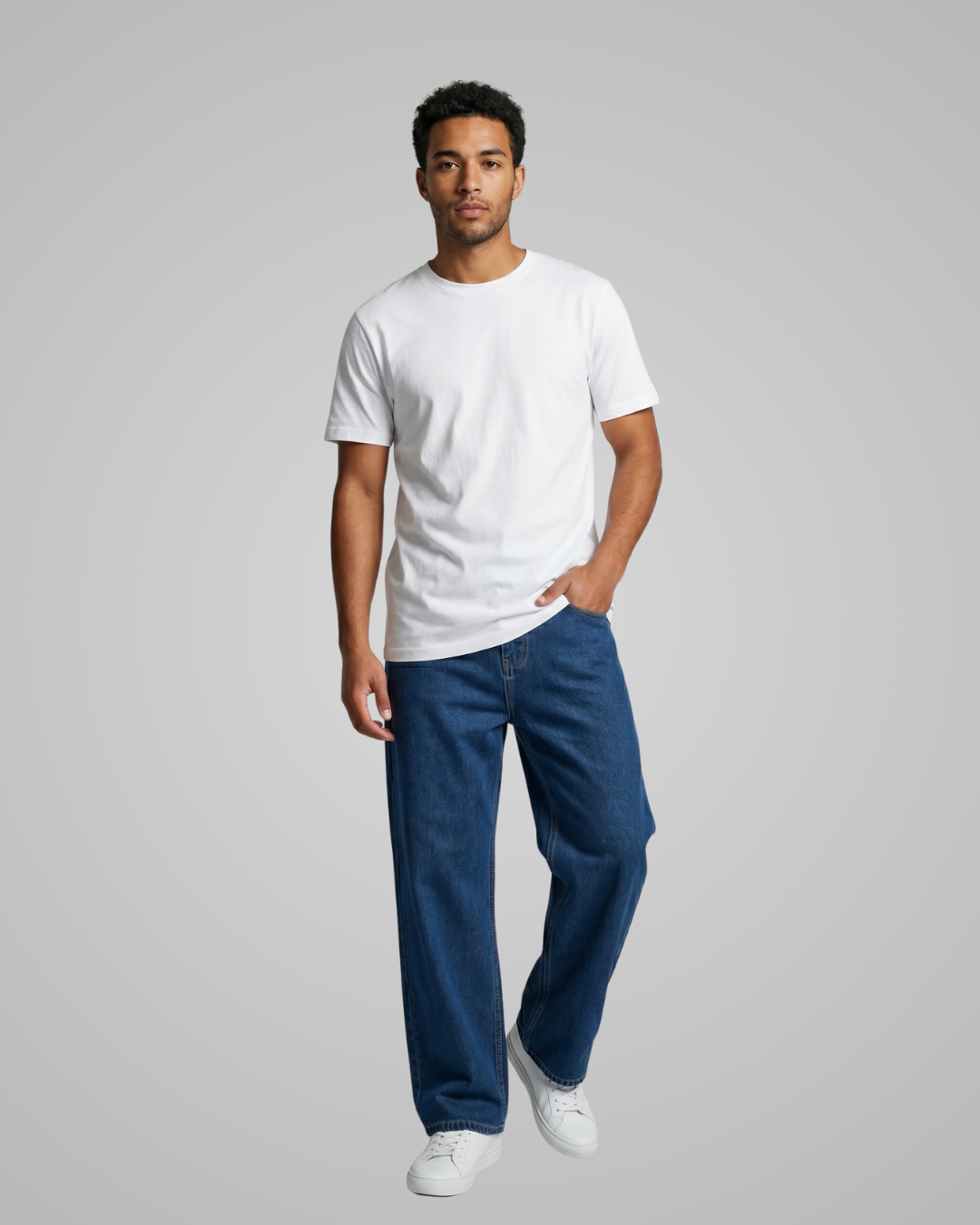 Man wearing a white t-shirt and blue jeans on a gray background