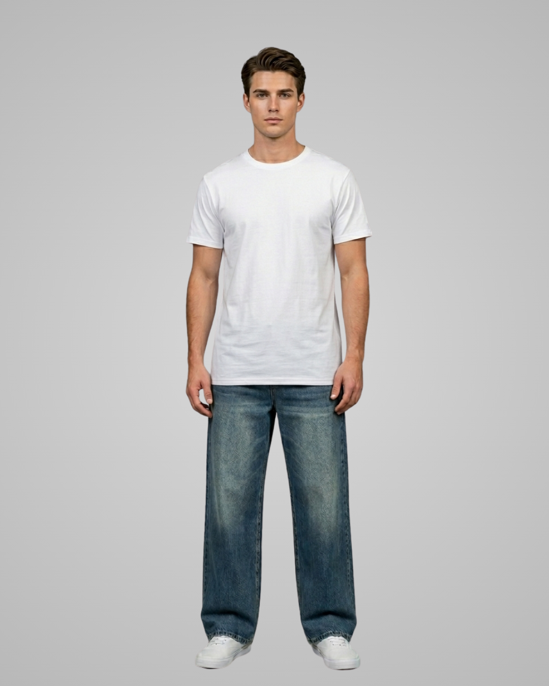 Man wearing a plain white t-shirt and blue jeans on a gray background