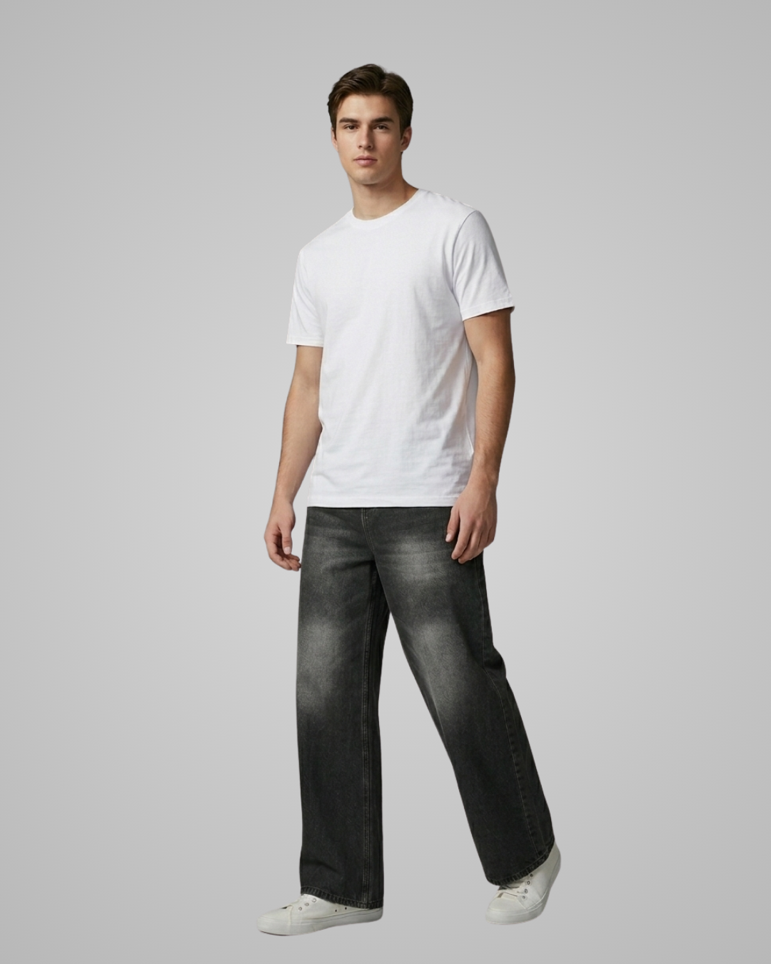 Man wearing a white t-shirt and black jeans on a gray background