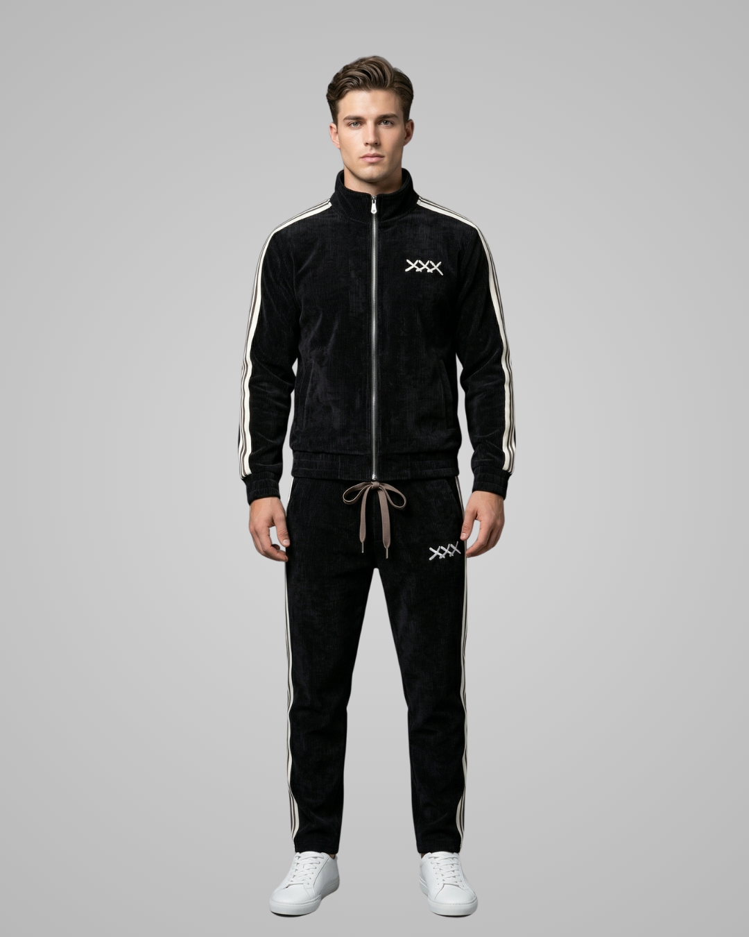 Man wearing a black tracksuit with white stripes on a gray background