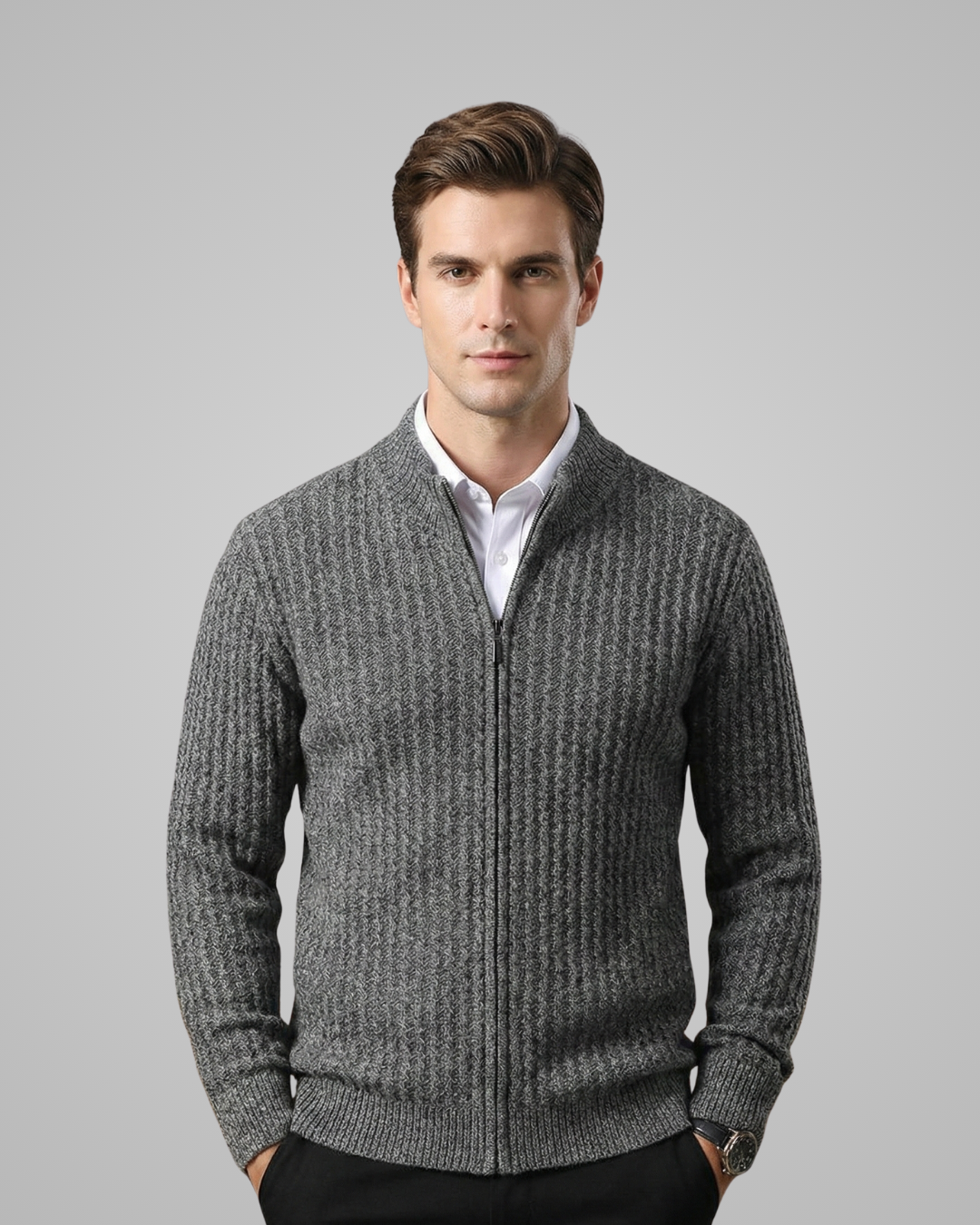 Man wearing a gray zip-up sweater over a white shirt on a gray background
