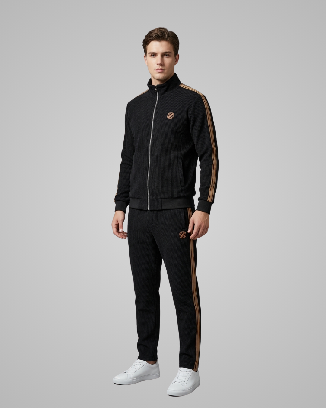 Man wearing a black tracksuit with gold stripes on a gray background
