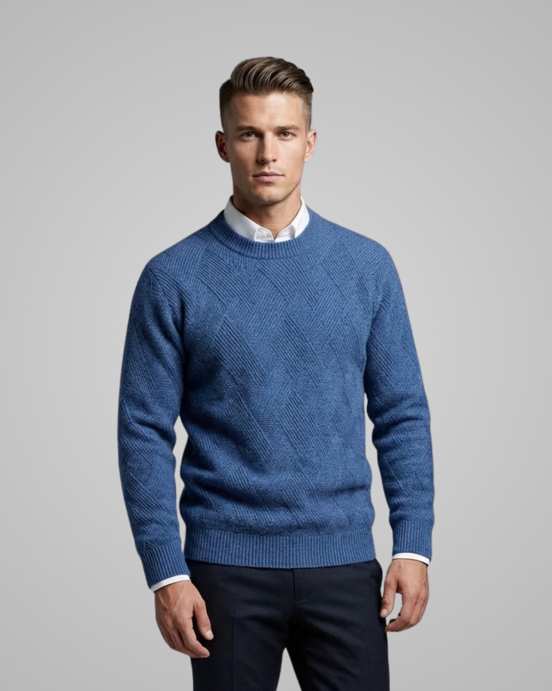 Man wearing a blue patterned sweater over a white shirt on a gray background