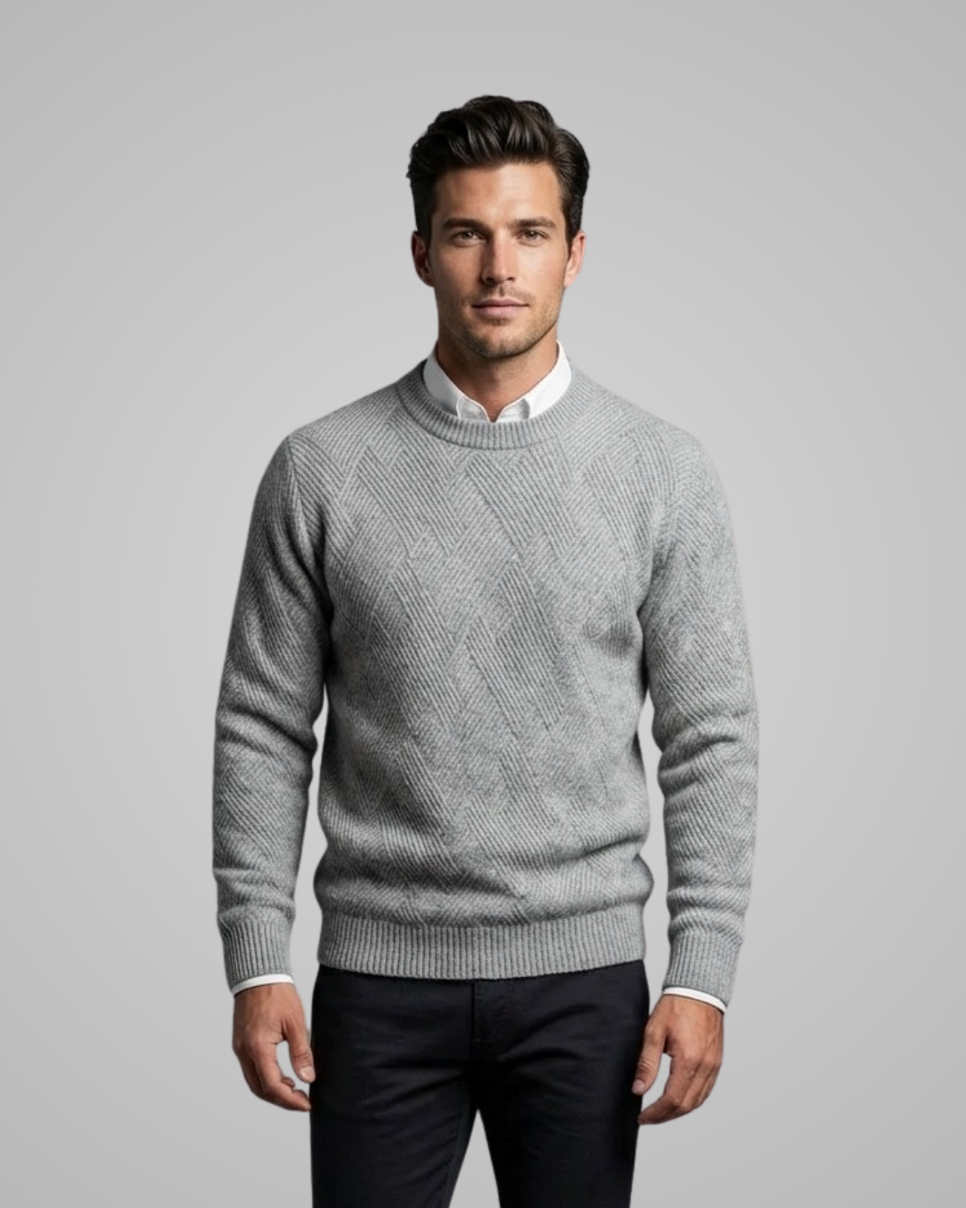 Man wearing a gray sweater over a white shirt on a gray background