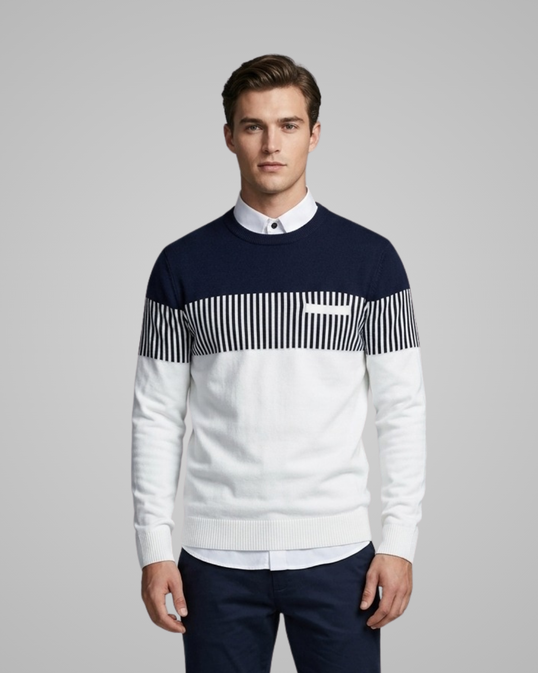 Man wearing a navy and white sweater with a striped pattern on a gray background