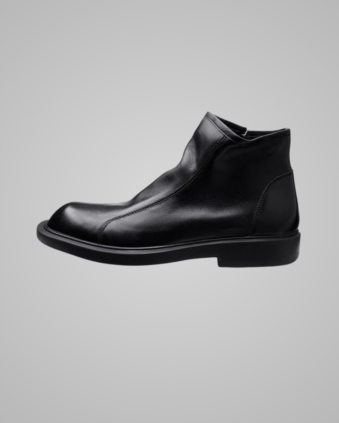 Black leather ankle boot on a gray background