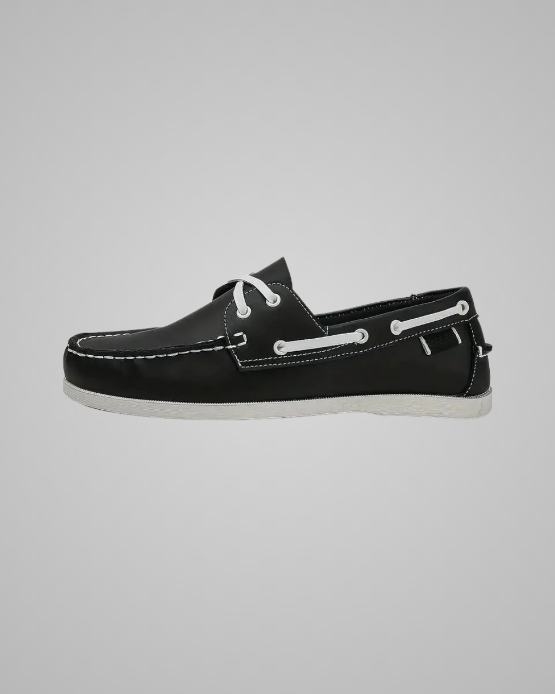 Black slip-on shoe with white sole on a white background
