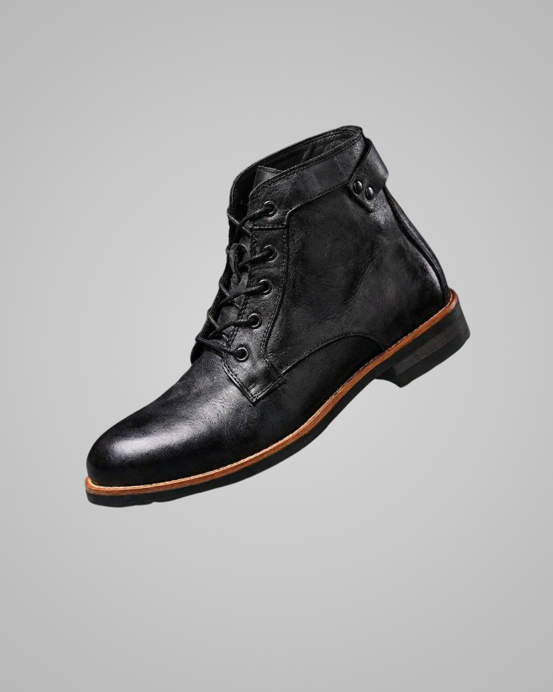 Black leather boot with brown sole on a gray background