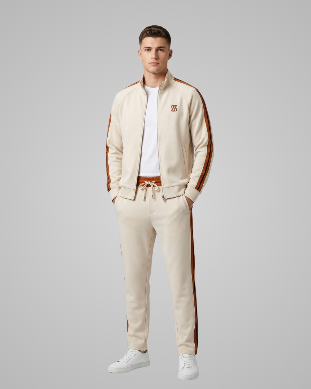 Man wearing a beige tracksuit with brown stripes on a gray background