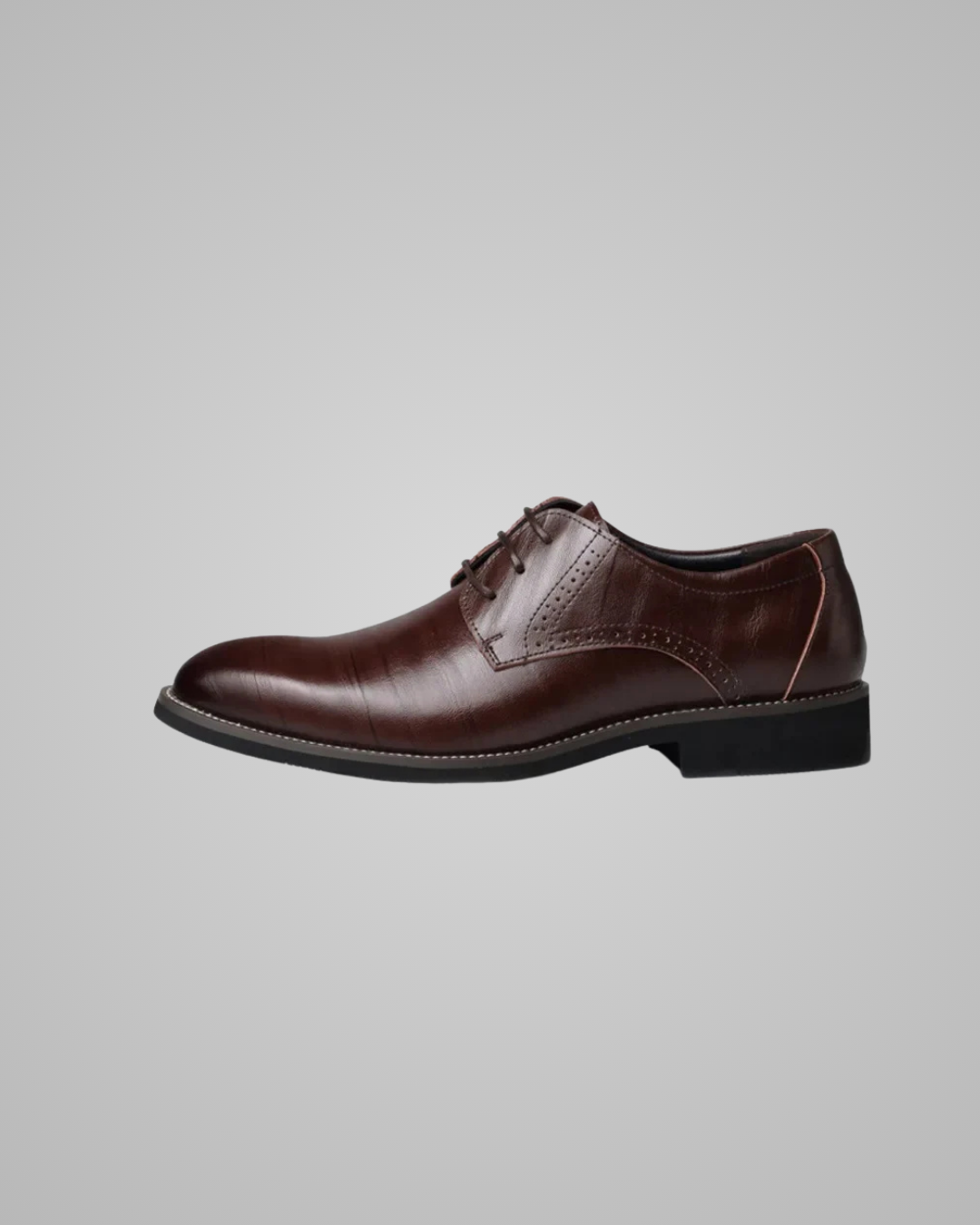 Brown leather dress shoe on a gray background