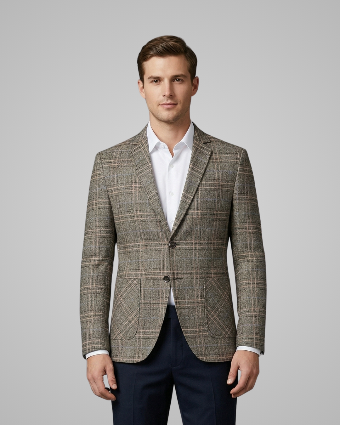 Man wearing a patterned blazer over a white shirt with a gray background