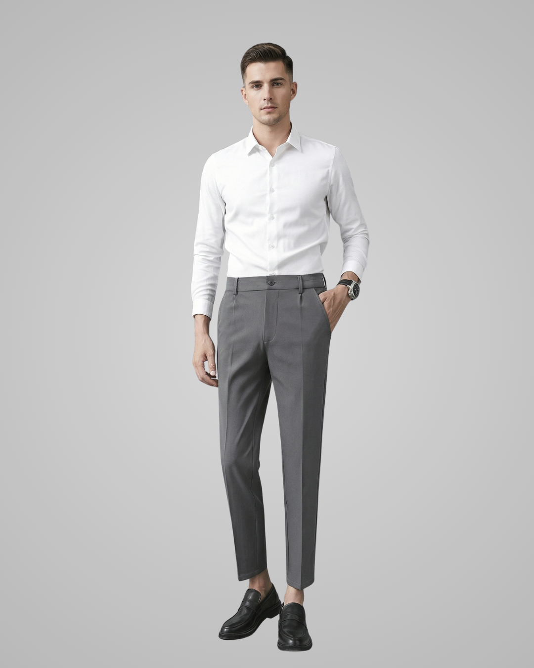 Man wearing a white shirt and gray pants on a gray background