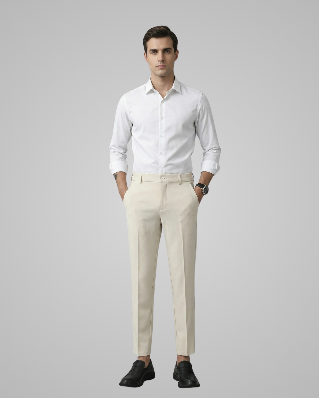 Man wearing a white dress shirt and beige pants against a gray background