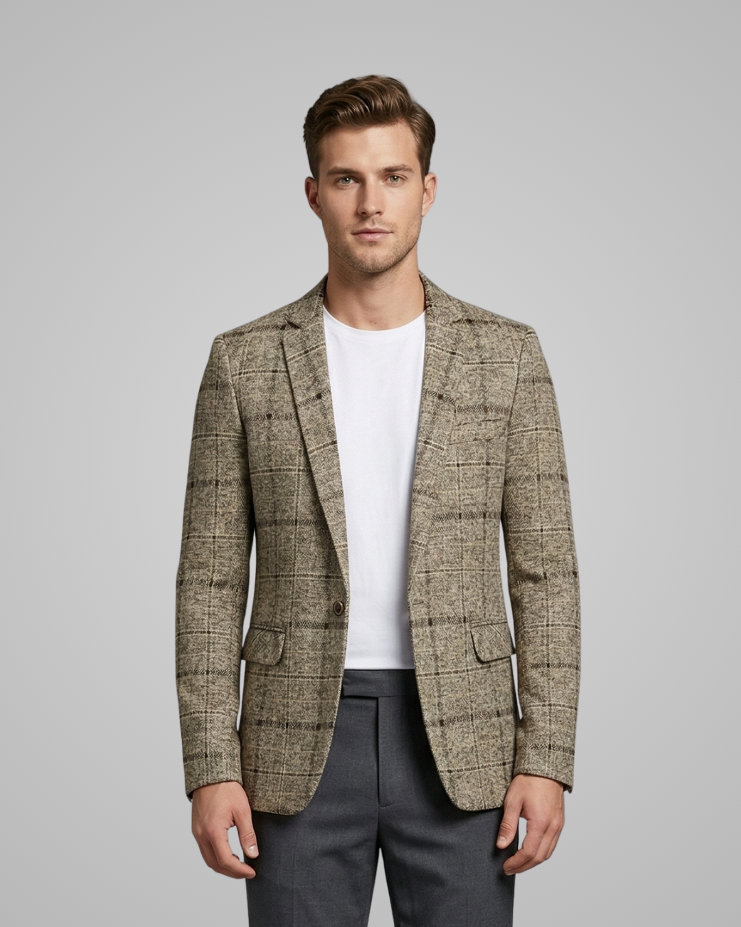 Man wearing a patterned blazer over a white shirt and dark pants on a gray background
