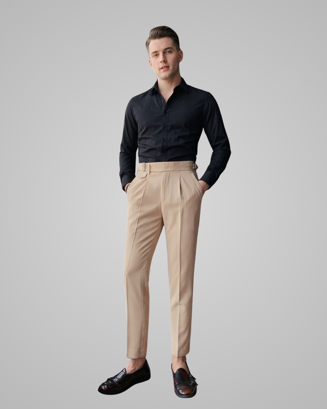 Man wearing a black shirt and beige pants on a gray background