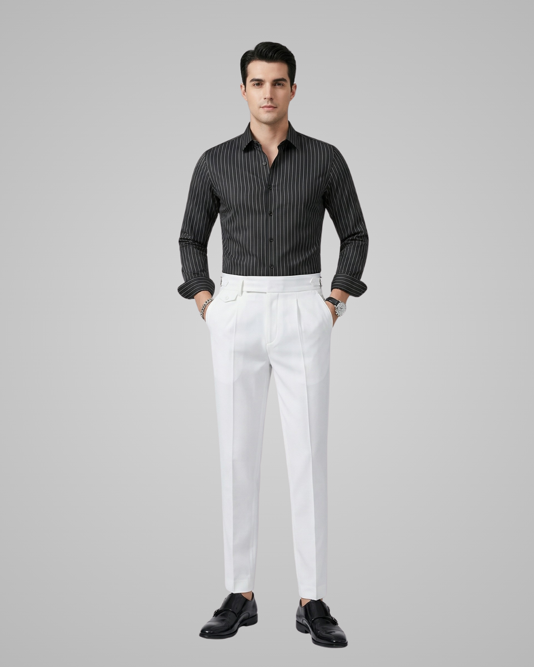 Man wearing a black striped shirt and white pants on a gray background