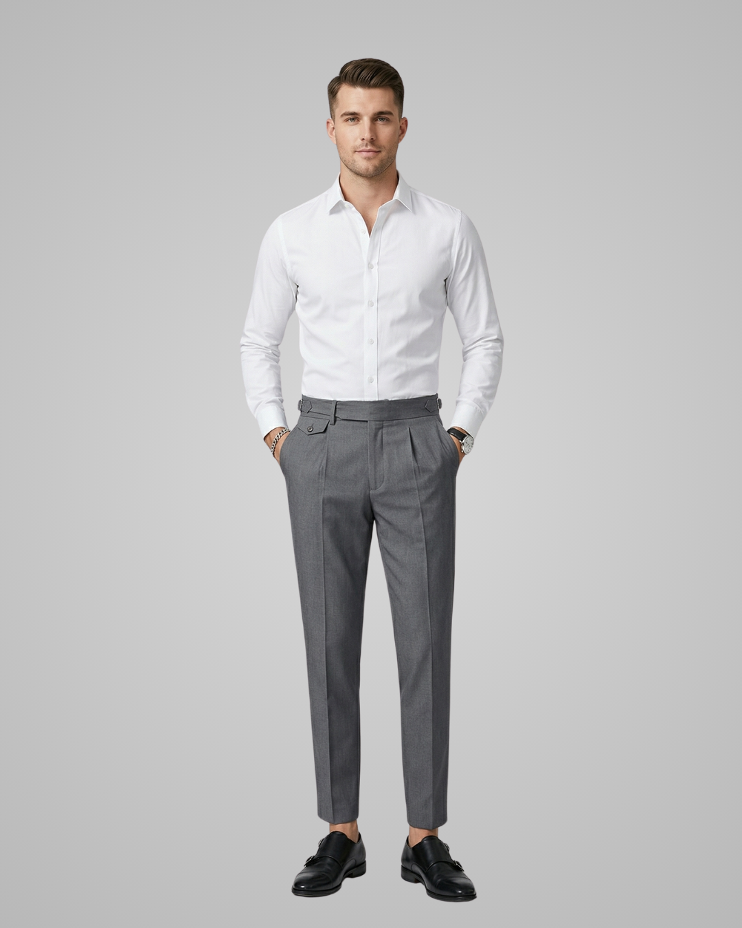 Man wearing a white dress shirt and gray trousers on a gray background