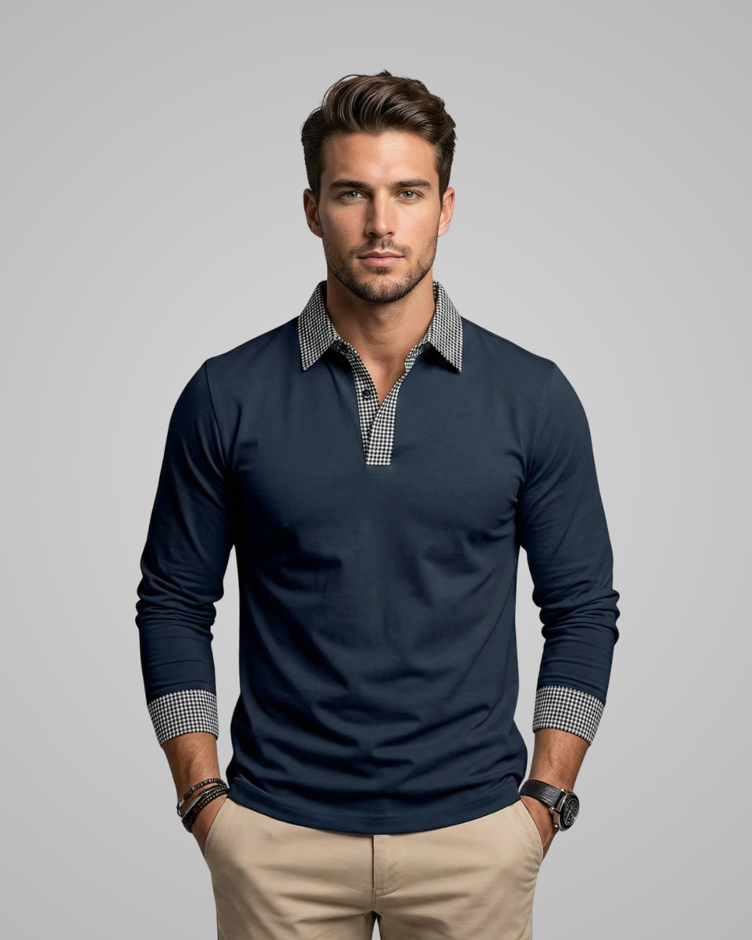 Man wearing a navy long-sleeve shirt with checkered collar and cuffs on a gray background