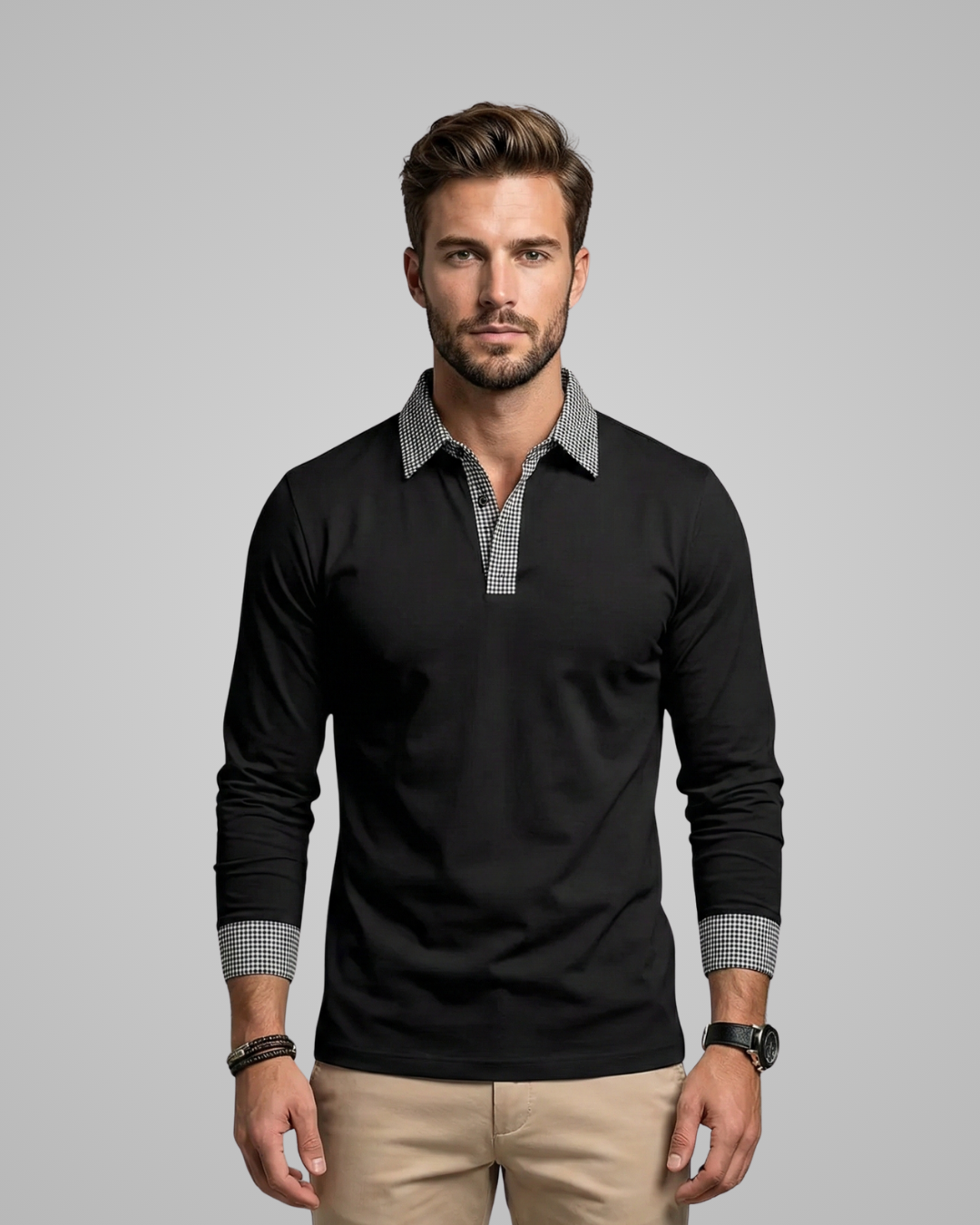 Man wearing a black long-sleeve shirt with patterned cuffs and collar against a gray background