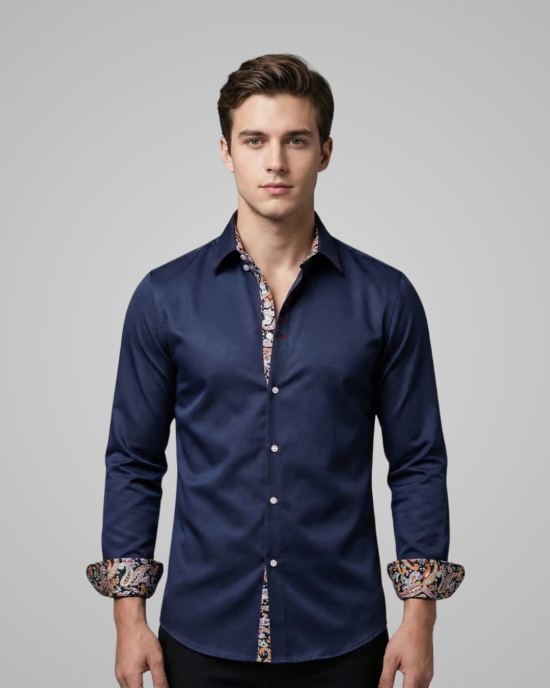 Man wearing a navy blue shirt with patterned cuffs on a gray background