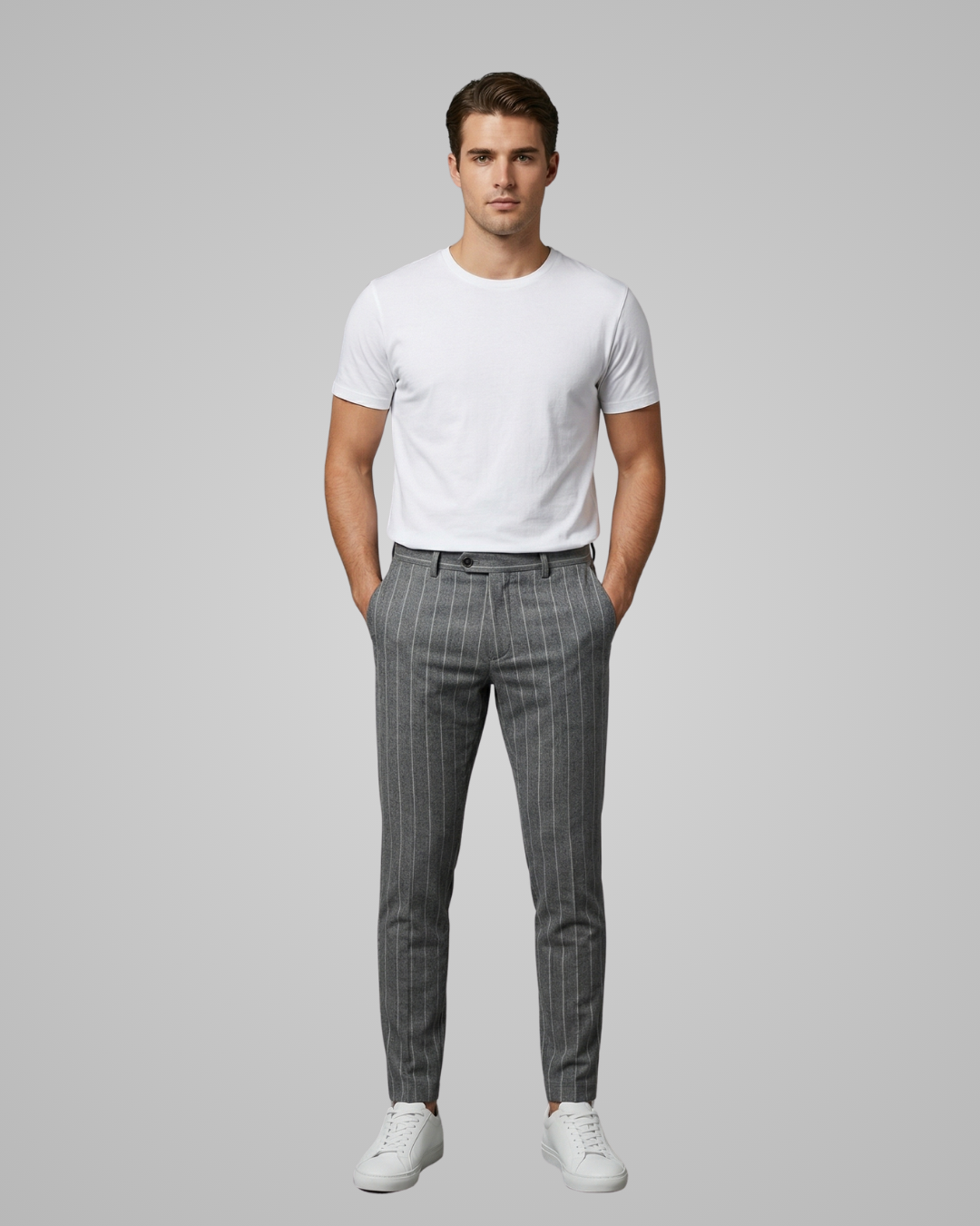 Man wearing a white t-shirt and gray checkered pants on a light gray background