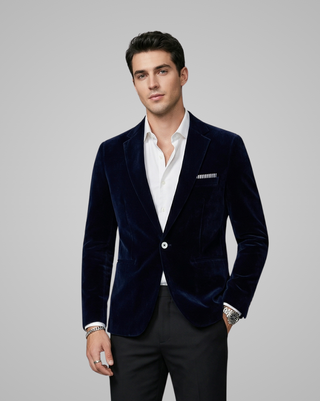 Man wearing a navy blue velvet blazer with a gray background