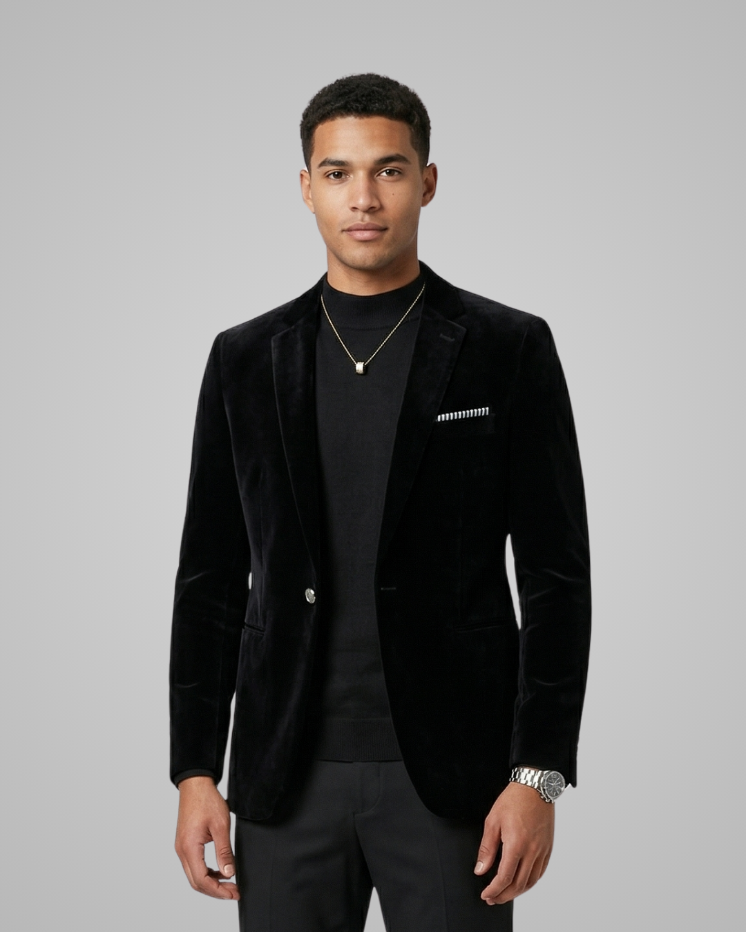 Man wearing a black velvet blazer with a gray background
