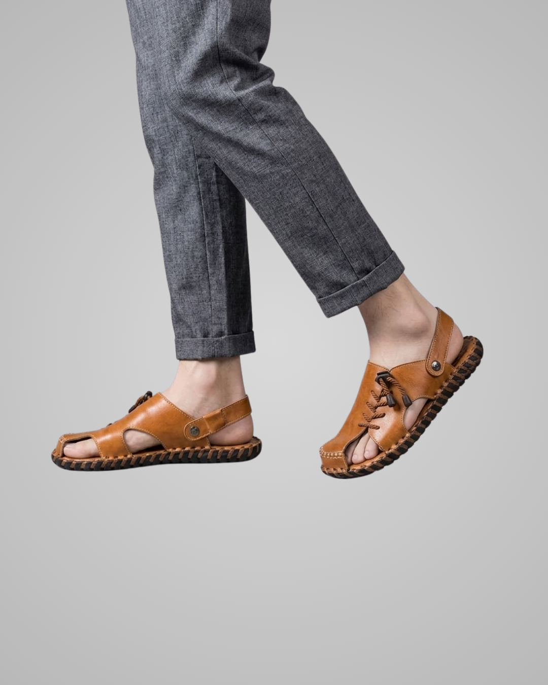 Brown sandals worn with gray pants on a light gray background