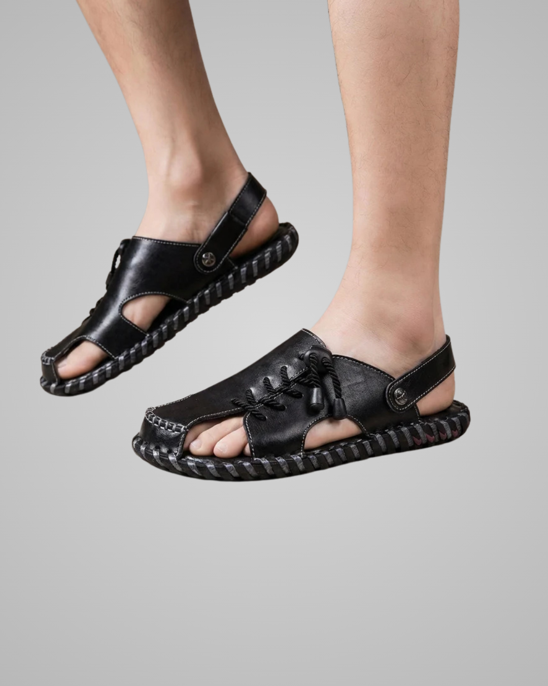 Black sandals worn by a person on a gray background