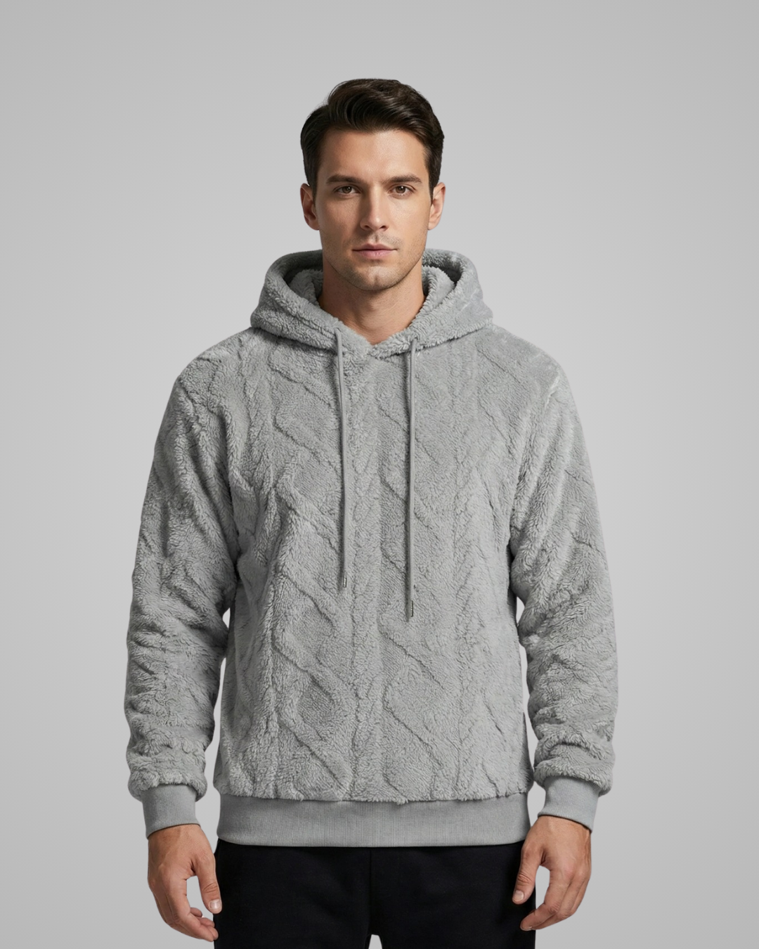 Man wearing a gray cable knit hoodie against a plain background