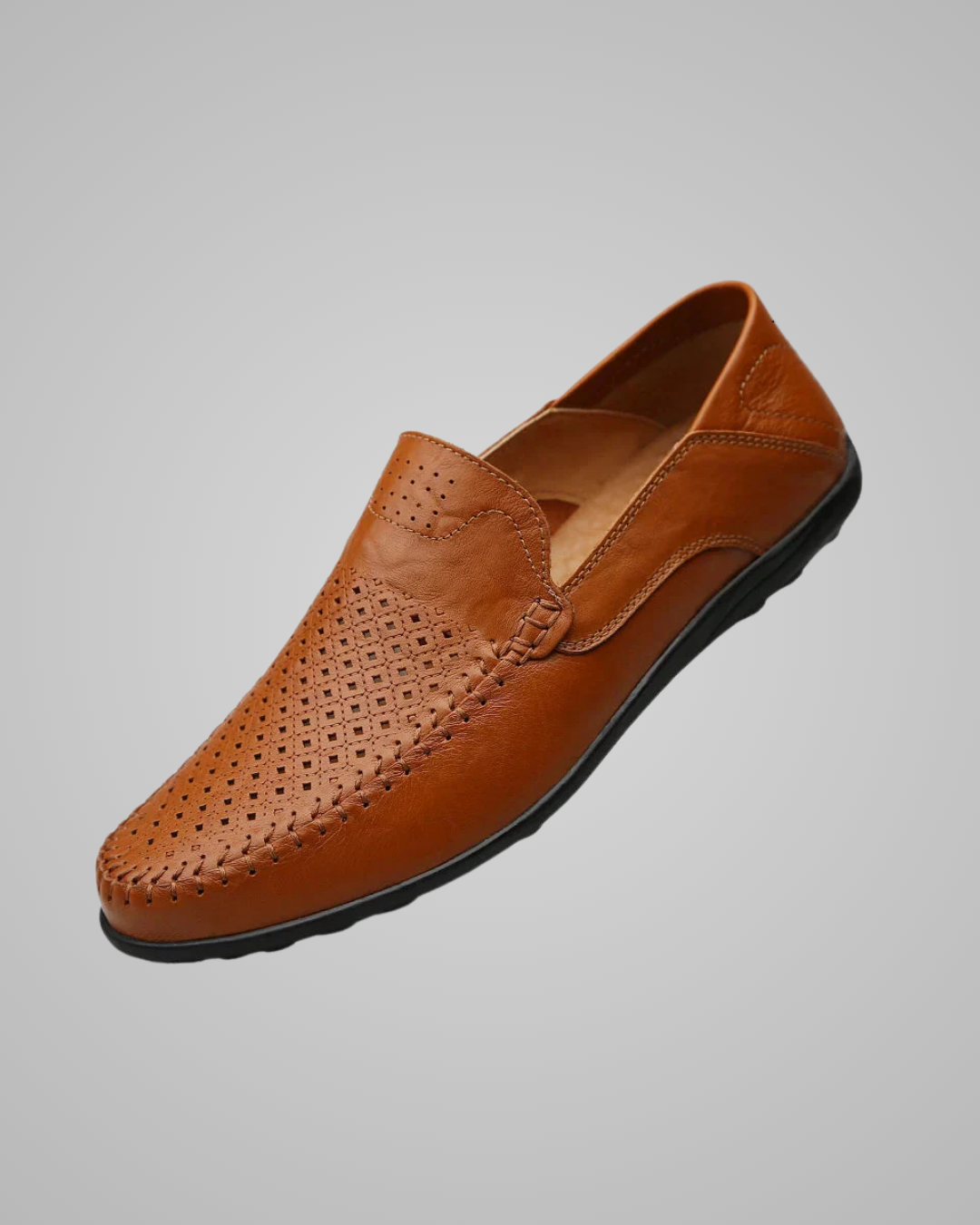 A single men's slip-on loafer in tan brown leather with perforated detailing on the toe and side, shown against a solid gray background.