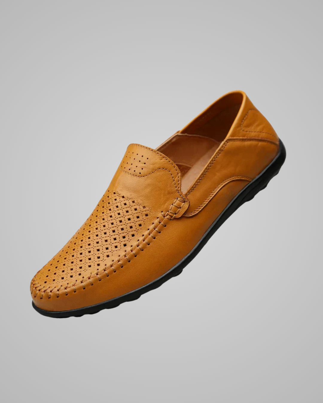A single men's slip-on loafer in tan leather with perforated detailing on the toe and side, shown against a solid gray background.