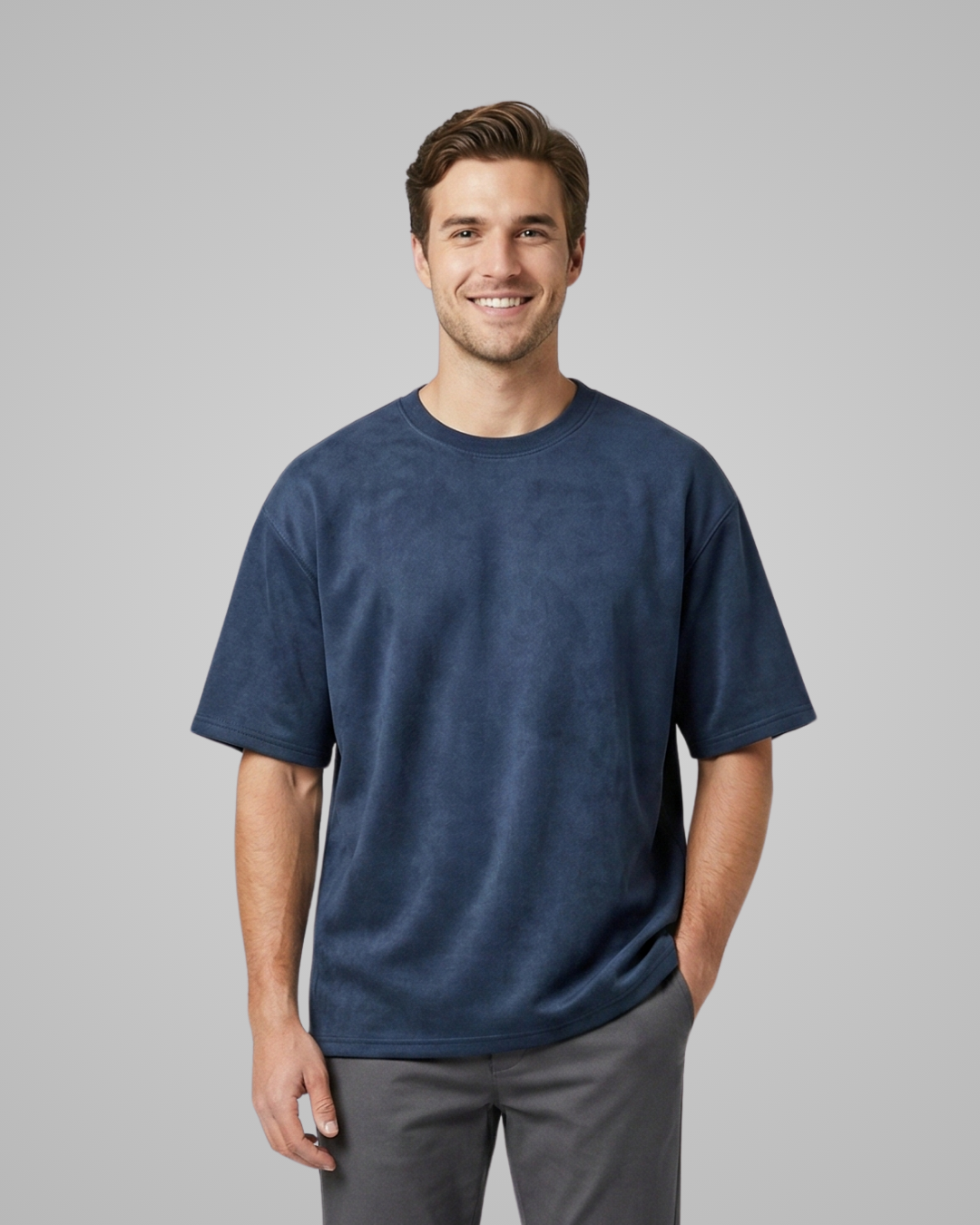 Man wearing a blue t-shirt against a gray background