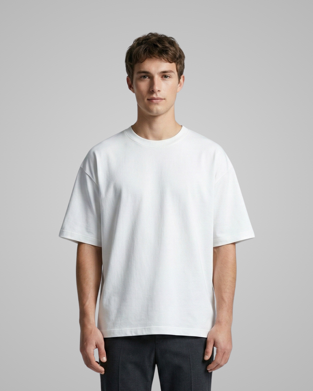 Man wearing a plain white t-shirt against a gray background