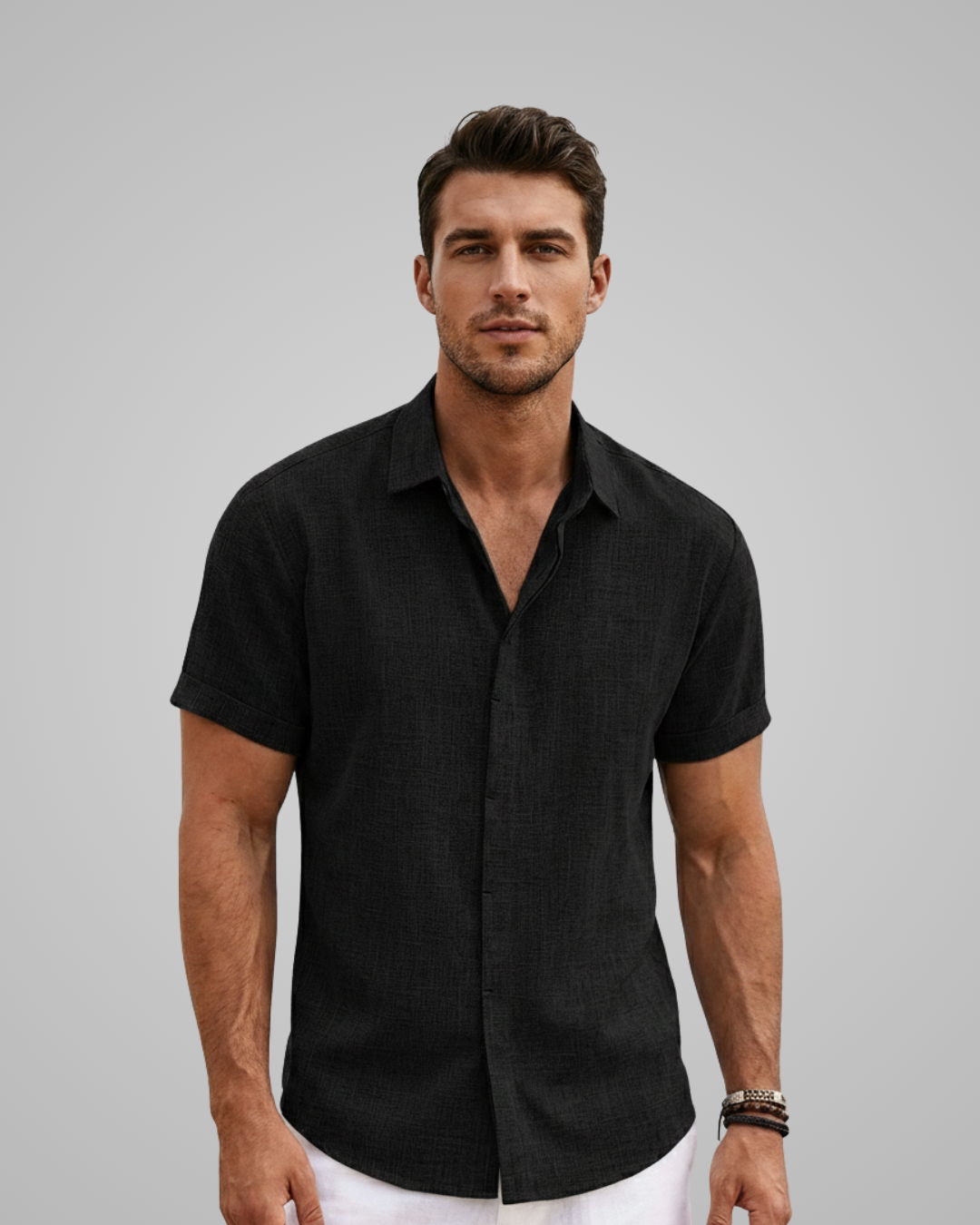 Man wearing a black short-sleeve shirt against a gray background