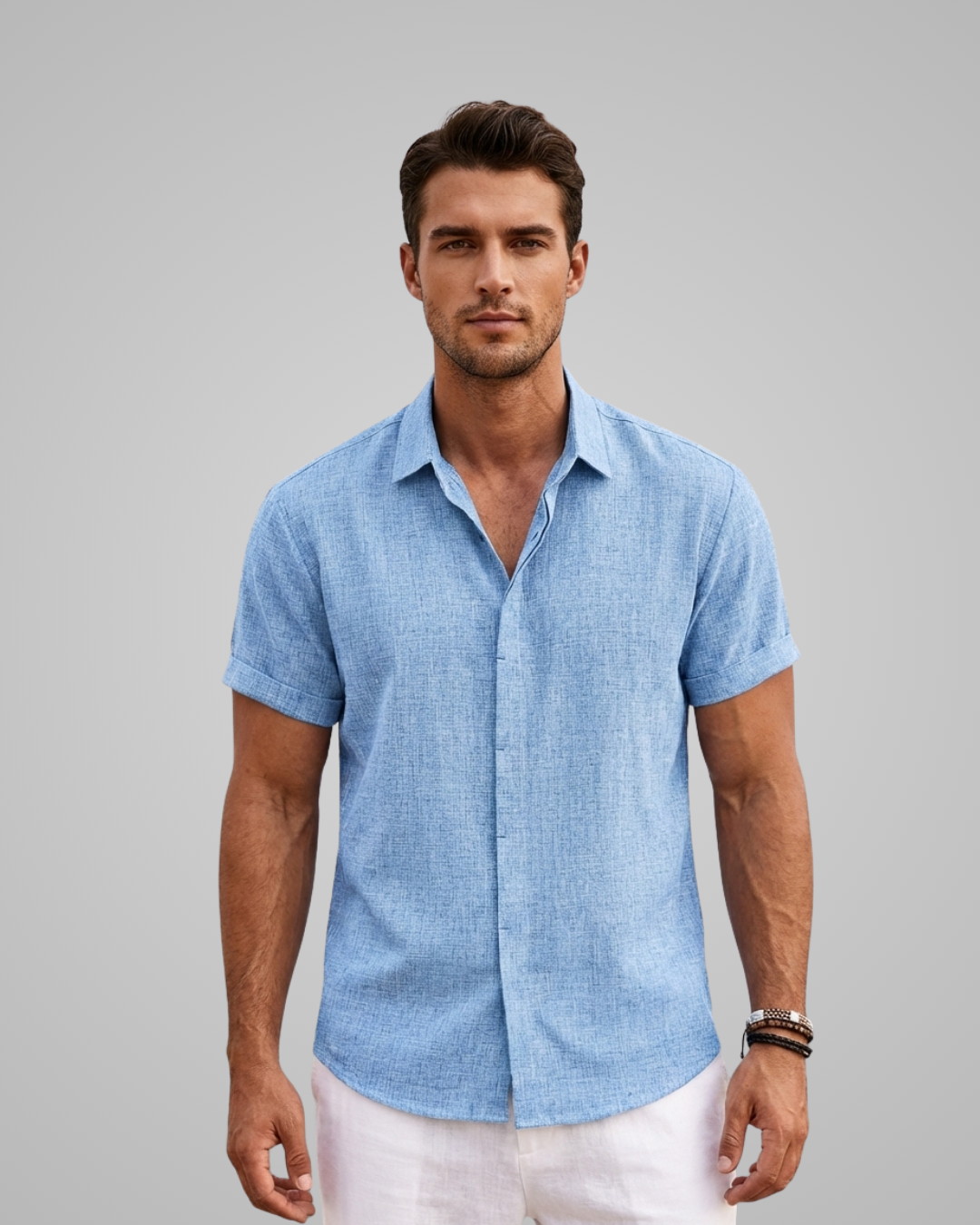 Man wearing a light blue short-sleeve shirt against a gray background