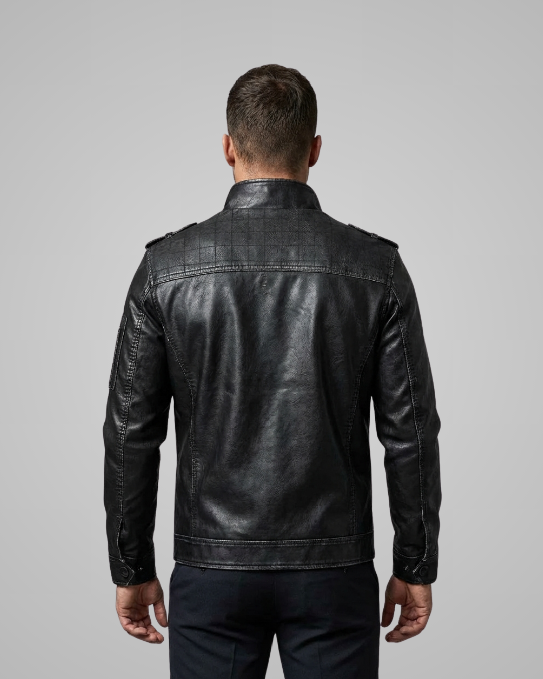 Man wearing a black leather jacket on a gray background