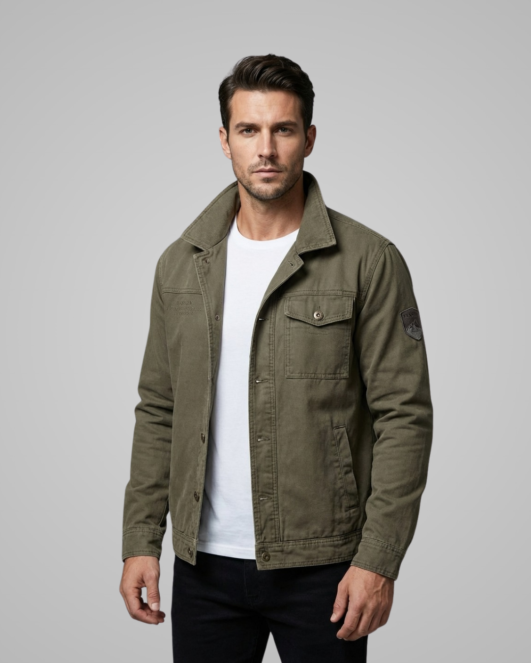 Man wearing a green jacket over a white shirt on a gray background