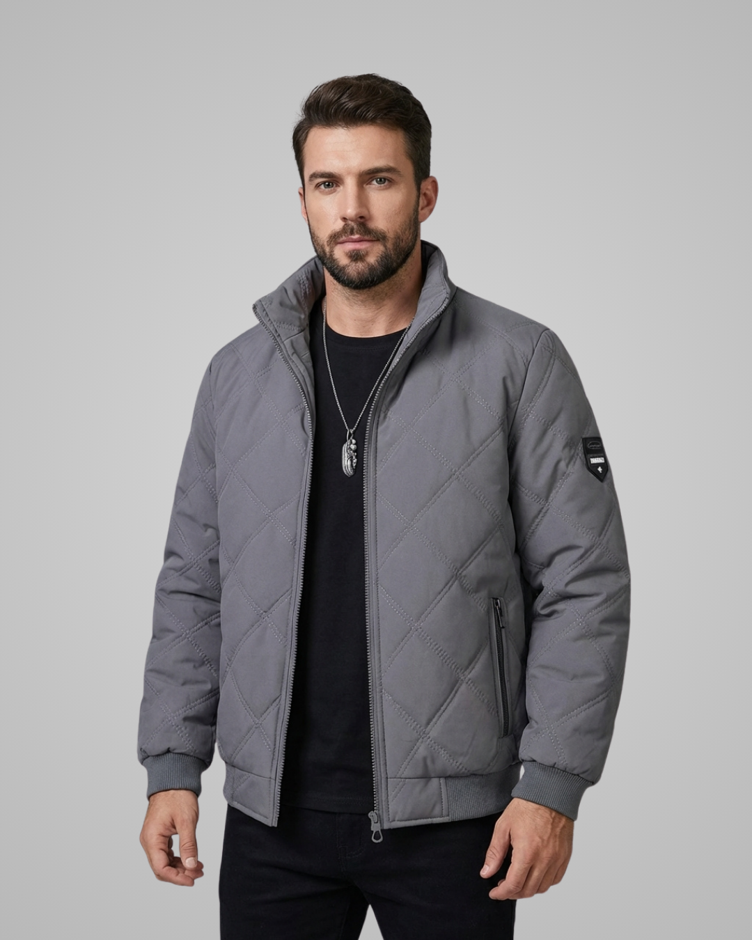 Man wearing a gray quilted jacket on a light gray background
