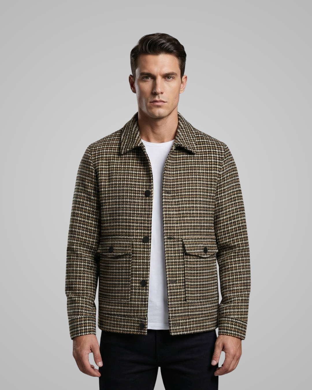 Man wearing a plaid jacket over a white shirt on a gray background