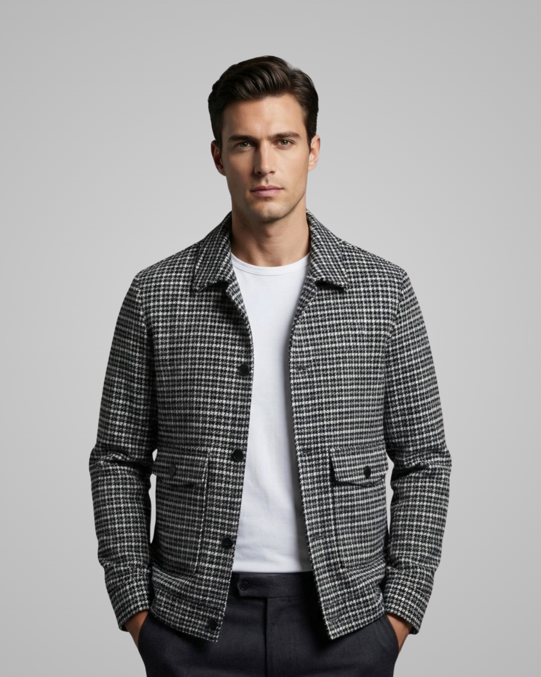 Man wearing a checkered jacket over a white shirt on a gray background