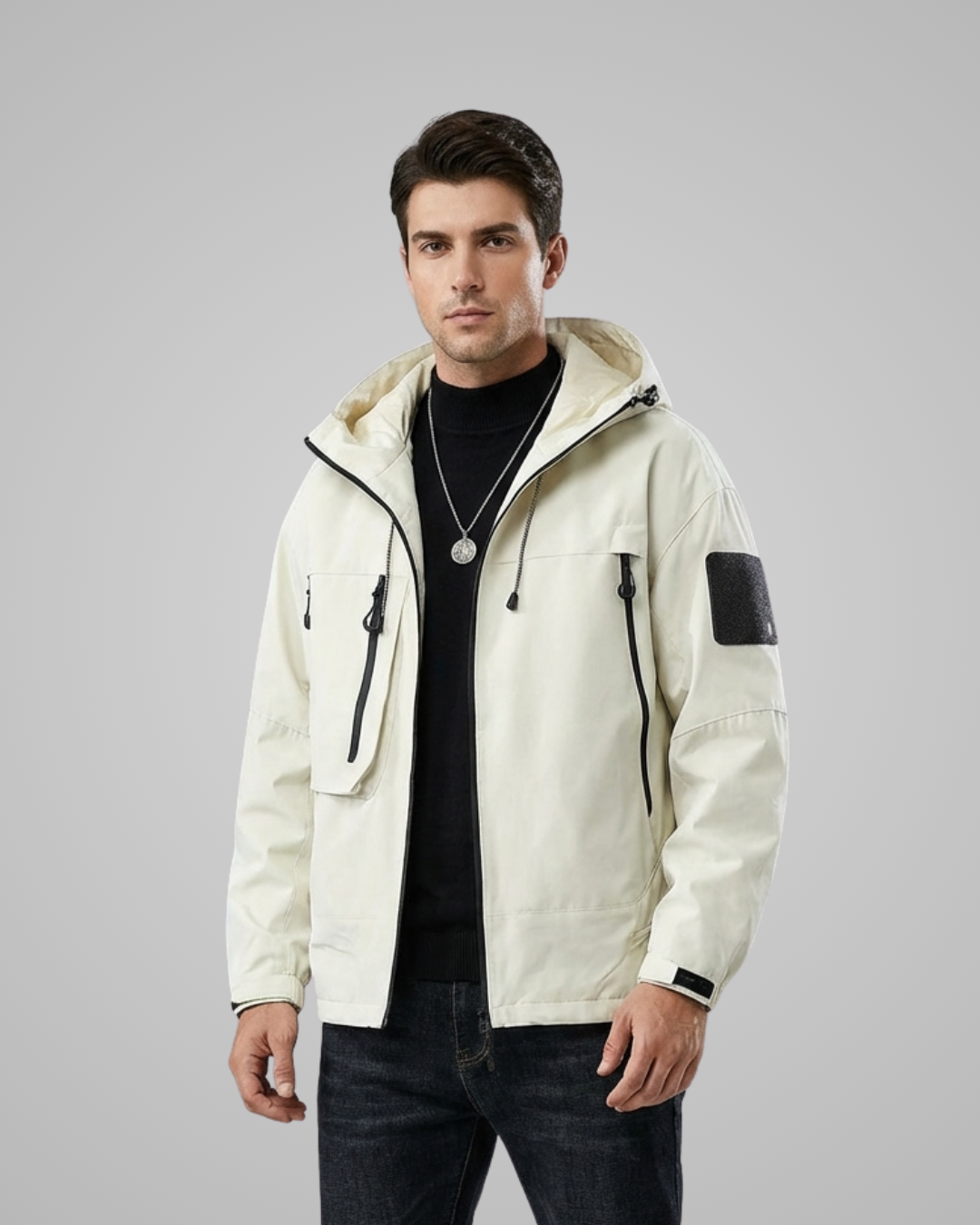 Man wearing a cream-colored jacket with black accents on a gray background