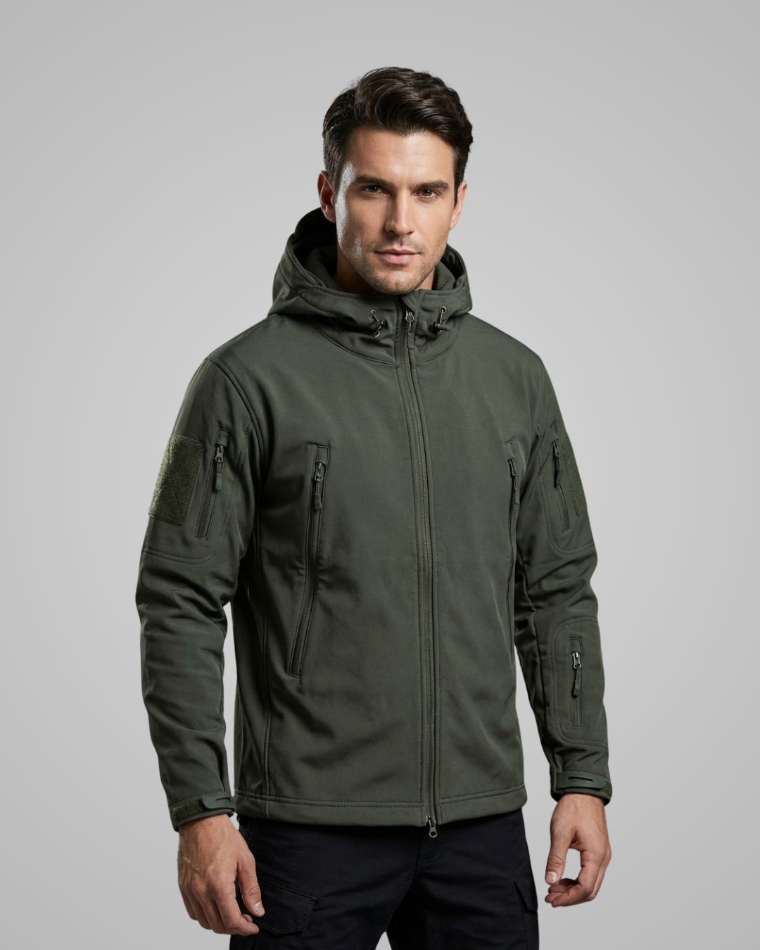 Man wearing a green tactical jacket on a gray background